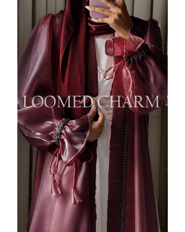 Luxurious Noya Silk Organza Shrug Abaya in soft pink with intricate crystal embellishments, featuring a satin inner, adjustable belt, and matching white chiffon scarf.