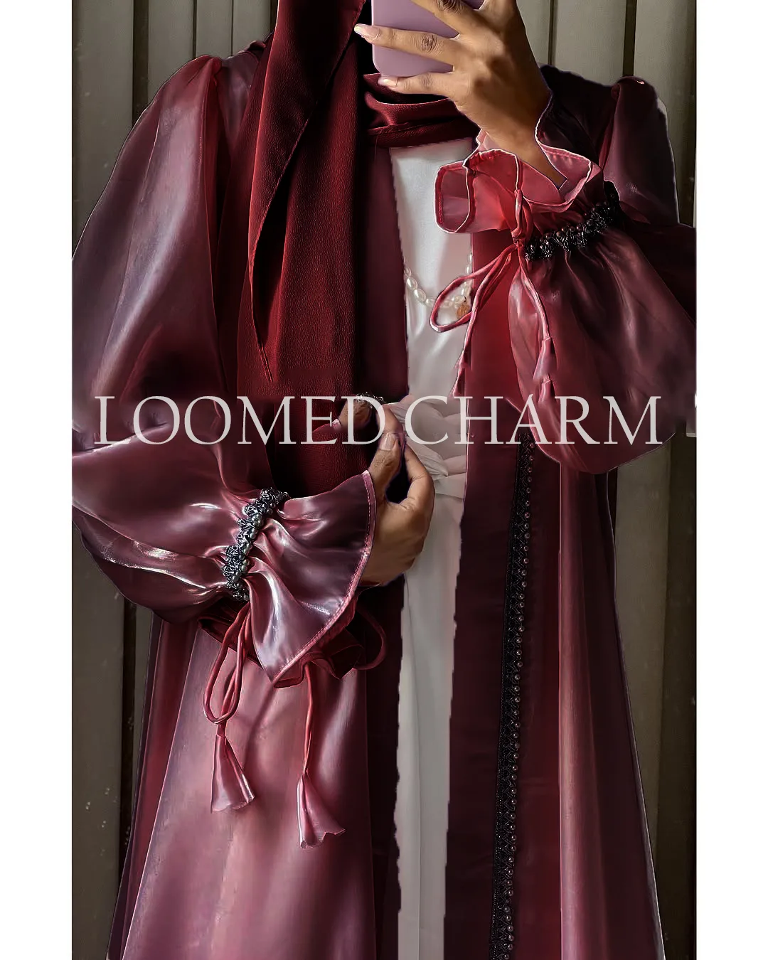 Luxurious Noya Silk Organza Shrug Abaya in soft pink with intricate crystal embellishments, featuring a satin inner, adjustable belt, and matching white chiffon scarf.
