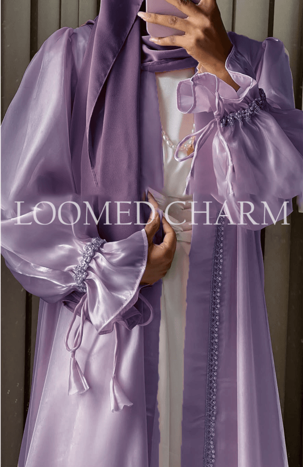 Luxurious Noya Silk Organza Shrug Abaya in soft pink with intricate crystal embellishments, featuring a satin inner, adjustable belt, and matching white chiffon scarf.